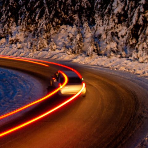 car leaving light trails on a winter road