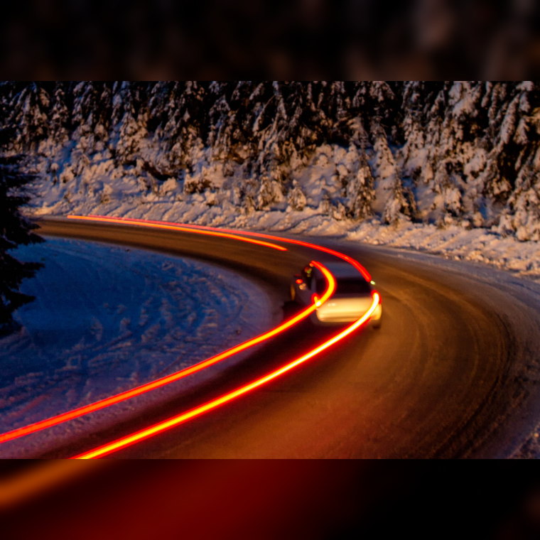 car leaving light trails on a winter road